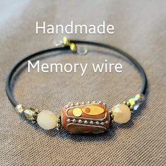 the handmade memory wire bracelet is decorated with glass beads and gold - tone accents