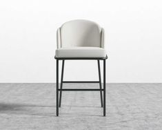 a white chair sitting on top of a cement floor next to a black metal frame