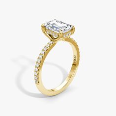 a yellow gold engagement ring with an oval cut diamond in the center and side stones