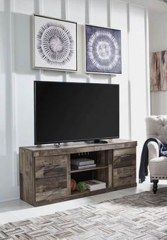 a living room scene with focus on the entertainment center and large screen tv mounted to the wall