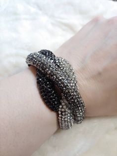 This piece is a gorgeous newer vintage piece, I would estimate to be from aprox the 90s. The piecs is a clamper style bracelet in gunmetal color. The piece is full of clear, grey metallic and black rhinestones. The inside measures aprox 6.75 inches. Please see all pictures on this piece for a better description and sizing. 13 Black Crystal Party Bracelet, Black Crystal Bracelet For Party, Silver Crystal Bangle For Evening, Silver Metal Crystal Evening Bracelet, Silver Metal Crystal Bracelet For Evening, Evening Metal Crystal Bracelet, Black Rhinestone, Clear Rhinestones, New Vintage