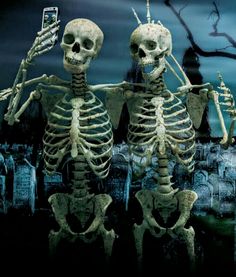 two skeletons standing next to each other in front of a cemetery