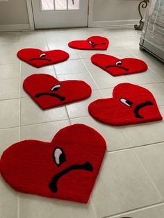 red heart shaped rugs with angry faces on the floor in front of a door