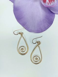 Expertly crafted from 14 high-quality gold-filled wire, these handmade elegant swirl earrings are a must-have for any jewelry collection. Measuring 2 inches long, they add a touch of sophistication and class to any outfit. Elevate your style with these stunning and versatile dangle earrings. Gold-filled wire contains 100 times more real gold than gold-plated wire and is durable and tarnish-resistant. Gold-filled jewelry is a beautiful, affordable alternative to solid gold. They are handcrafted with love. Swirl Yellow Gold Earrings For Gift, Yellow Gold Swirl Earrings For Gift, Elegant Spiral Wire Wrapped Hoop Earrings, Gold Swirl Earrings For Pierced Ears, Gold Spiral Wire Wrapped Hoop Earrings, Gold Wrap Earrings With Ear Wire, Gold Swirl Wire Wrapped Jewelry, Gold Wire Wrapped Swirl Jewelry, Elegant Swirl Wire Wrapped Earrings