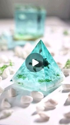 a glass pyramid sitting on top of white rocks