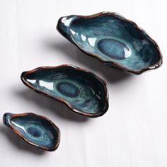 three blue bowls sitting on top of a white table