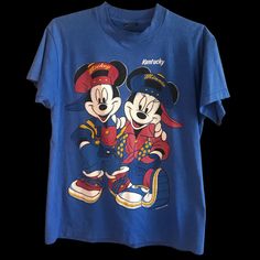 For Mickey And Minnie Disney Fans! Or Vintage Tshirt Fans That Want All Things Kentucky! This Unique T-Shirt Is Unisex, Size L. Add To Your Mickey Collection! There Is Some Light Cracking Slightly Visible On The White Of The T-Shirt But No Rips, Holes Or Tears. Mickey Mouse Short Sleeve Top For Fans, Short Sleeve Mickey Mouse Tops For Fans, Blue Disney Tops For Fan Events, Blue Cartoon Print Tops For Disney Fan Events, Blue Crew Neck Tops In Pop Culture Style, Blue Crew Neck Top In Pop Culture Style, Retro Cartoon Print Tops For Disney Fan Events, Blue Crew Neck Top With Pop Culture Style, Pop Culture Mickey Mouse Tops For Disney Fan Events