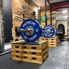 a gym with squat plates and benches in front of the barbells on display