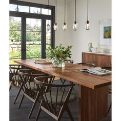 a dining room table with chairs and a vase filled with flowers