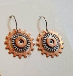 two pairs of earrings with gears on them