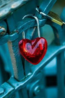 a red heart hanging from a metal hook