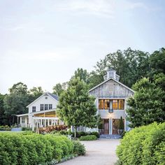 a large white house surrounded by trees and bushes