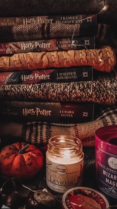 many harry potter books are stacked on top of each other with candles in front of them