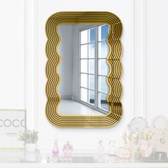 a mirror that is sitting on top of a shelf next to a table and vase