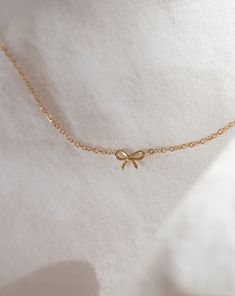 Discover the charm of the coquette era with our 14k Gold Dainty Bow Necklace. The small, delicate bow is ideal for everyday wear, making it a must-have accessory. • 14k Yellow Gold• Bow measures about 6mm Small Dainty Jewelry, Bow Necklace Gold, Gold Bow Necklace, Cute Gold Necklace, Cute Necklaces, Aesthetic Necklace, Schmuck Gold, Dainty Gold Jewelry, Preppy Jewelry