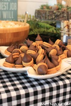 desserts and snacks are displayed on plates at a buffet table with black and white checkered cloth