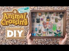 someone is holding up a wooden frame with animals on it and the words, animal crossing diy