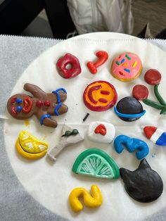 a white plate topped with lots of different shaped doughnuts on top of a table