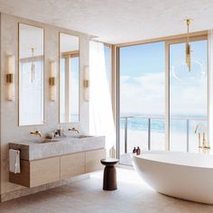 a bathroom with a large bathtub next to a big window overlooking the beach and ocean