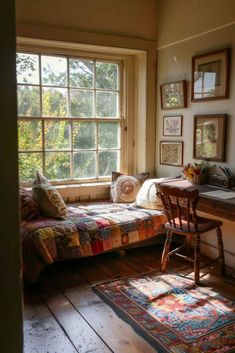 a bedroom with a bed, desk and window in the corner next to an area rug