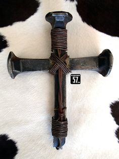 a cross made out of metal and rope on top of a cowhide rug with the number 37 attached to it