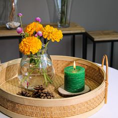 a vase filled with yellow flowers sitting on top of a table next to a lit candle