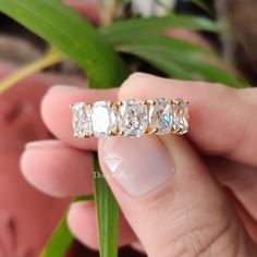 a person holding a diamond ring in their hand