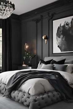 a bedroom with black walls and white bedding, chandelier hanging from the ceiling