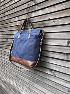 Tote bag with luggage handle attachment in American heavy weight waxed canvas. The color is navy blue for the body and camel leather bottom. I made it into an everyday bag perfect for the office, with leather handles, shoulder strap, and 3 outside pockets Closing with a zipper on top. And on the backside a luggage handle attachment Including a leather shoulder strap, adjustable and detachable. Fully lined with a cotton canvas and double inside pockets. All the bags are made and designed by mysel Blue Shoulder Bag With Leather Trim For Everyday, Everyday Blue Shoulder Bag With Leather Trim, Everyday Waxed Canvas Bag With Luggage Sleeve, On-the-go Waxed Canvas Bag With Leather Handles, Blue Canvas Satchel For Everyday Use, Navy Shoulder Bag With Leather Handles For On-the-go, Navy Canvas Shoulder Bag With Leather Handles, Navy Leather Handled Satchel Shoulder Bag, Navy Satchel Shoulder Bag With Leather Handles