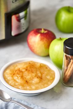 apples, cinnamon sticks and apple cider on a table