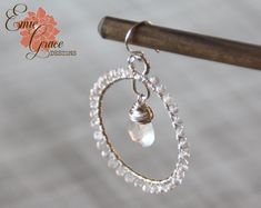 "These beautiful hoop earrings are made of sterling silver, clear quartz and pearl white chalcedony by hand with attention to detail. Would make beautiful bridal jewelry with their sparkle and shine! The large clear quartz briolettes that hang suspended at the center of the large silver hoops are a bit cloudy giving them a intentionally imperfect look that really is stunning. The pearl white chalcedony has a lovely pearly quality that really sparkles in the light. All wire, jump rings, ear wires Handmade Clear Hoop Jewelry, Single Round Clear Earring, Handmade Silver Crystal Hoop Earrings, Silver Round Crystal Earrings Wire Wrapped, Silver Round Crystal Earrings, Wire Wrapped, Nickel-free Clear Jewelry For Wedding, Beautiful Bridal Jewelry, Earrings Wire, Sterling Silver Bangles