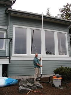 a man standing in front of a gray house