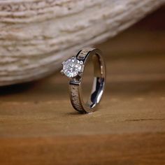 a diamond ring sitting on top of a wooden table