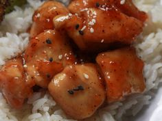 chicken with sesame seeds on top of rice and broccoli