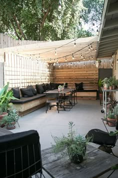 an outdoor living area with patio furniture and potted plants