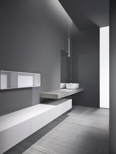 an image of a bathroom with grey walls and white fixtures on the counter top, along with two sinks