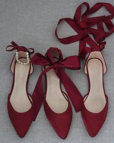 three pairs of red shoes tied up to each other with a pearl beaded shoelace