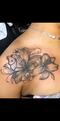 a woman's breast with flowers and butterflies tattoo on the side of her stomach