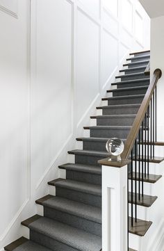 the stairs in this house are made of wood and gray carpet, along with white walls