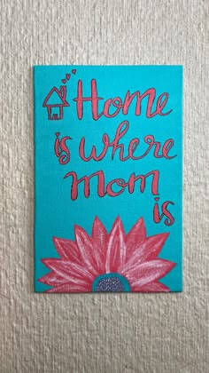 there is a painting on the wall that says, home is where mom is