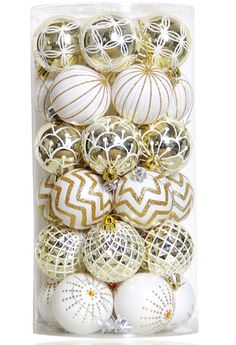 an assortment of white and gold ornaments in a clear box on a white background photo