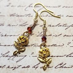 Rose Flower Dangle Earrings with Burgundy Faceted Glass Bead. Dangle approx 2".  Hypo-allergenic gold-tone ear wires. Handmade Copper Gold Flower Earrings, Handmade Gold Flower Earrings In Copper, Gold Wire Wrapped Flower Earrings Gift, Adjustable Gold Flower Earrings, Gold Flower-shaped Copper Earrings, Gold Drop Earrings With Rose Design, Gold Dangle Flower Earrings With Rose Design, Gold Dangle Earrings With Rose Design, Adjustable Gold Rose Design Jewelry