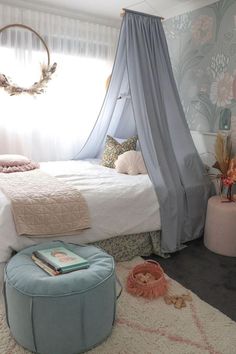 a bedroom with a canopy bed next to a window and rugs on the floor