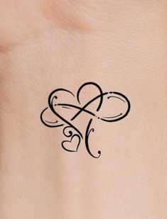 a small tattoo on the back of a woman's stomach, with two hearts