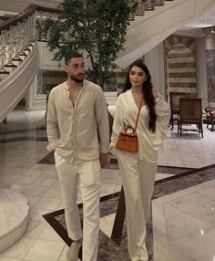 a man and woman standing in front of a staircase