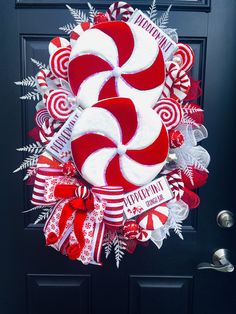 a wreath made to look like a candy cane wreath on the front door for christmas