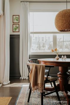 a dining room table with two chairs and a rug on the floor next to it