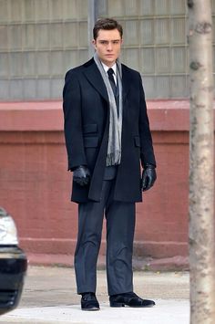 a man in a suit and tie standing on the street