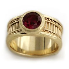 a yellow gold ring with a red stone in the center and roped band around it