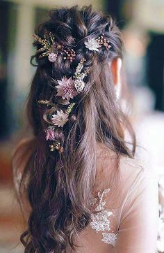 a woman with long hair and flowers in her hair is wearing a flowered headpiece